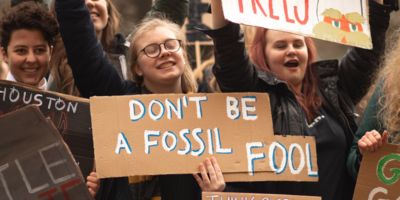 Young climate protesters holding signs/ CC0 Callum Shaw