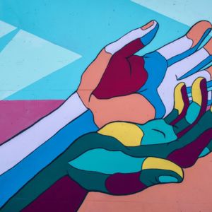 Artwork painting of colourful hands on a wall/ CC0 Tim Mossholder