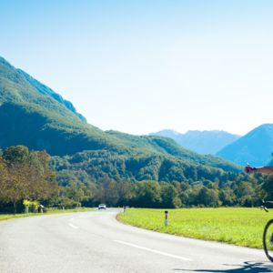 Man on bicycle riding towards mountains