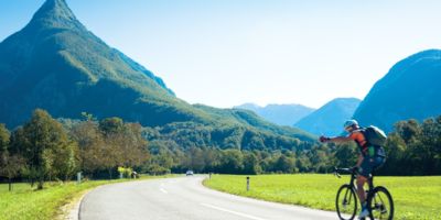 Man on bicycle riding towards mountains