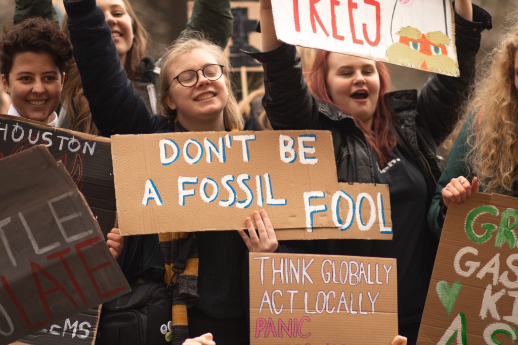 Young climate protesters holding signs/ CC0 Callum Shaw