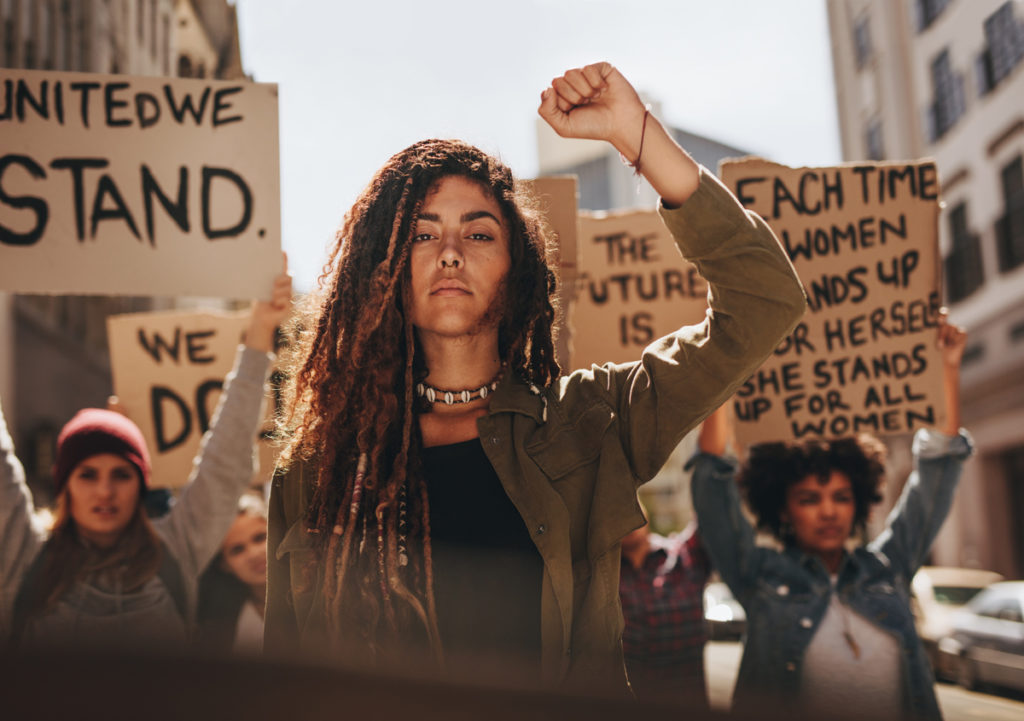 Person with raised fist during protest/ shutterstock