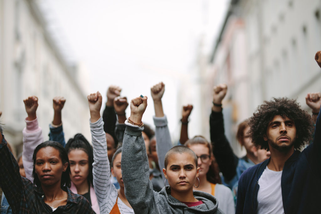 Persons with raised fists during protest/ shutterstock